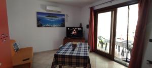 Camera con tavolo, TV e finestra di Casa vacanze Simona a Budoni