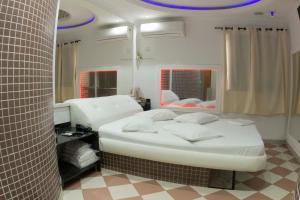 A bed or beds in a room at Studio Motel (Adult Only)