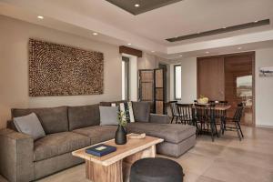 uma sala de estar com um sofá e uma mesa em Beachfront Alassa Villas with Private Pools em Kotrónion