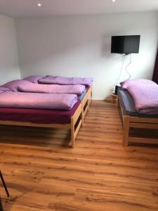 2 camas en una habitación con suelo de madera en EVASIONLOISIRS 
