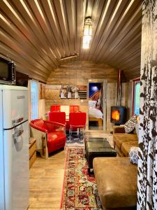 een woonkamer met rode meubels en een koelkast bij Gleis 2, Waggon mit Ofen, Whirlpool und Sauna in Dahlem