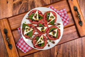 a plate of food with tomatoes and green peppers at KACLLA, The Healing Dog Hostel in Lima