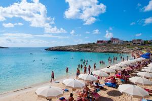 a group of people on a beach with umbrellas at Brezza Marina in Lampedusa