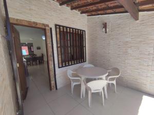 - une table et des chaises blanches dans la chambre dans l'établissement Casaportoazzurro, à Cabo Frio
