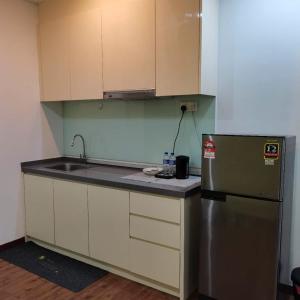 a kitchen with a sink and a refrigerator at Romance in de house 3-5pax Two Parking Free, There is a shopping mall downstairs in Kuala Lumpur