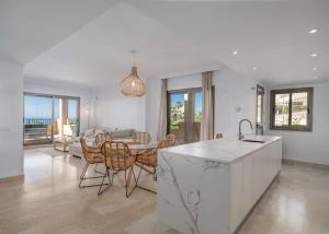 a kitchen and living room with a table and chairs at Superbe appartement avec vue mer in Estepona