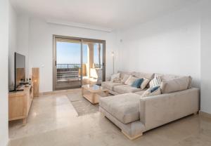 エステポナにあるSuperbe appartement avec vue merのソファとテレビのあるリビングルーム