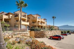 a building with cars parked in a parking lot at Superbe appartement avec vue mer in Estepona