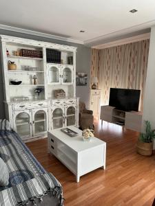 een woonkamer met een witte kast en een tv bij Cristina Apartamento Center in Valencia