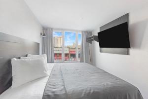 Hotel TREMONT Bronx Yankee Stadium في برونكس: غرفة نوم بسرير كبير وتلفزيون بشاشة مسطحة