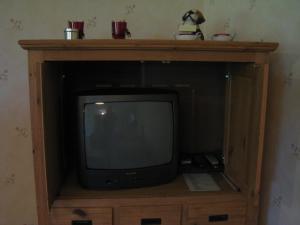 a tv sitting on top of a wooden entertainment center at De Kleen Meulen - max 6pers in Lummen