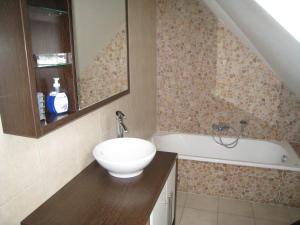 a bathroom with a sink and a bath tub at De Kleen Meulen - max 6pers in Lummen