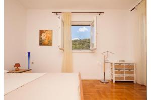 een witte kamer met een bed en een raam bij Apartment Milena in Novigrad Dalmatia