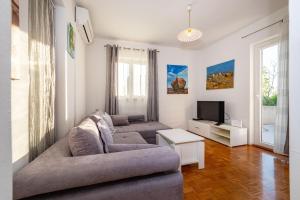 een woonkamer met 2 banken en een tv bij Apartment Milena in Novigrad Dalmatia