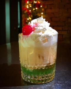 a drink with whipped cream and a cherry on a table at СЕЙФ: міні-готель 24х7 in Ivano-Frankivsʼk