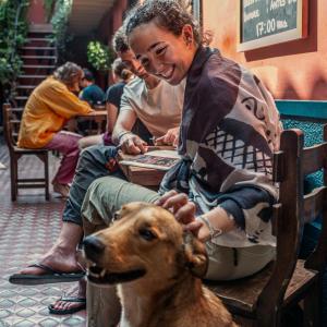 a woman sitting in a chair with a dog at KACLLA, The Healing Dog Hostel in Lima