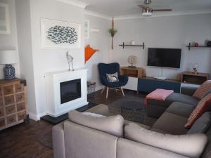 a living room with a couch and a fireplace at A Pebbles Throw - 300m from the beach. in Westward Ho