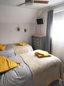 a bedroom with two beds with yellow sheets and a window at A Pebbles Throw - 300m from the beach. in Westward Ho