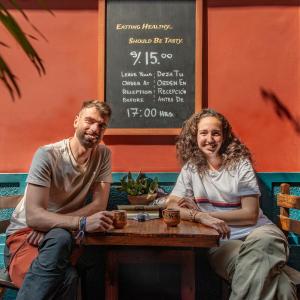 a man and a woman sitting at a table at KACLLA, The Healing Dog Hostel in Lima