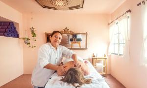 a woman is sitting on a bed with a man at KACLLA, The Healing Dog Hostel in Lima