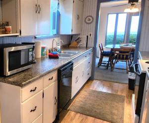 a kitchen with a sink and a microwave at PA Crows Nest Cottage in Port Angeles
