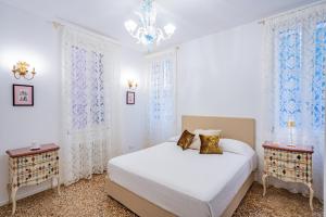 Ca' San Beneto Completely Refurbished in a fabulously central area في البندقية: غرفة نوم بيضاء بسرير وليلتين