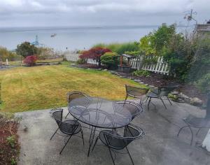 a patio with a table and chairs in a yard at PA Crows Nest Cottage in Port Angeles