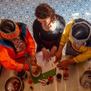 a group of three women standing around a table preparing food at KACLLA, The Healing Dog Hostel in Lima