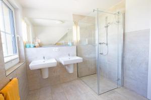 un bagno con due lavandini e una doccia in vetro di Haus Seemannsgarn a Zingst