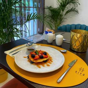 un plato de comida con fruta en una mesa en DIVA HOTEL LIGNANO - Adults Only, en Lignano Sabbiadoro