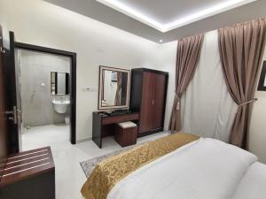a bedroom with a bed and a sink and a mirror at الشرق بارك للشقق المخدومة in Al Mikhlaf