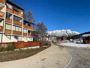 pusta droga przed budynkiem z ośnieżonymi górami w obiekcie Studio Rénové 4 Pers. au Pied des Pistes avec Parking Gratuit - Résidence Les Fontettes, La Joue du Loup - FR-1-504-646 w mieście Dévoluy +7 zdjęć