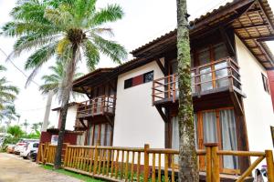 una casa con una valla de madera y una palmera en Cond. Fechado, na Ponta do Mutá, en Maraú