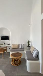 a living room with two beds and a table at Nomikos Villas in Fira