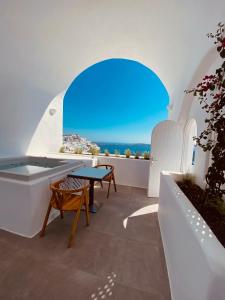 Zimmer mit einem Tisch und Meerblick in der Unterkunft Nomikos Villas in Fira