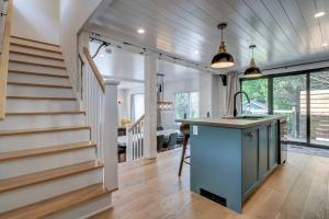 een keuken met een eiland in een kamer met een trap bij Maison 3 chambres à coucher vue sur la montagne in Bromont