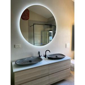 La salle de bains est pourvue de 2 lavabos et d'un miroir. dans l'établissement Villa Casa Collina Castelfalfi with amazing salt waterpool & AIRCO & VIP service, à Castelfalfi