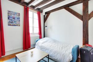 een kamer met een bed, een tafel en een raam bij Quartier Latin - Charmant studio - Bail mobilité in Parijs