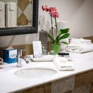 a bathroom sink with a vase of flowers on it at Inn at the Mill, Ascend Hotel Collection in Fayetteville