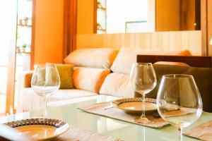 3 copas de vino sentadas en una mesa en una sala de estar en Apartamentos Residencial Conte 5 min da Rua Coberta by Achei Gramado, en Gramado