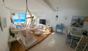 a living room with a table and a dining room at la ventana al mar in Jávea