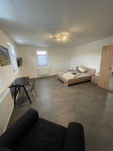 ein großes Wohnzimmer mit einem Bett und einem Schreibtisch in der Unterkunft MR Ferienwohnung - Wohnung Emma in Schellerten