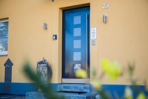 eine blaue Tür mit einer Vase vor einem Gebäude in der Unterkunft Treppendorfer Apartments in Treppendorf