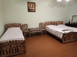 two beds in a room with wooden floors at Berdavan Guesthouse in Berdavan