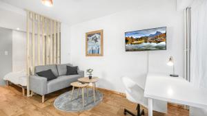 ein Wohnzimmer mit einem Sofa und einem Tisch in der Unterkunft HOMEY HARBOR - Proche Tram - Parking gratuit - Balcon privé - Wifi & Netflix in Ambilly