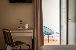 Habitación con escritorio y silla junto a una ventana en BYPILLOW Erba, en Girona