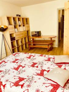1 dormitorio con cama, mesa y banco en Studio au pied des pistes en Villard-de-Lans