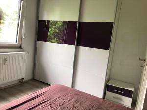 1 dormitorio con 1 cama con espejo en la pared en Ferienwohnung an der Nordsee en Sande