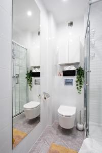 a white bathroom with a toilet and a shower at Apartments Old Town by Arrenda in Warsaw