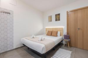 1 dormitorio con 1 cama y armario de madera en Dobohomes - Clara del Rey 33, en Madrid